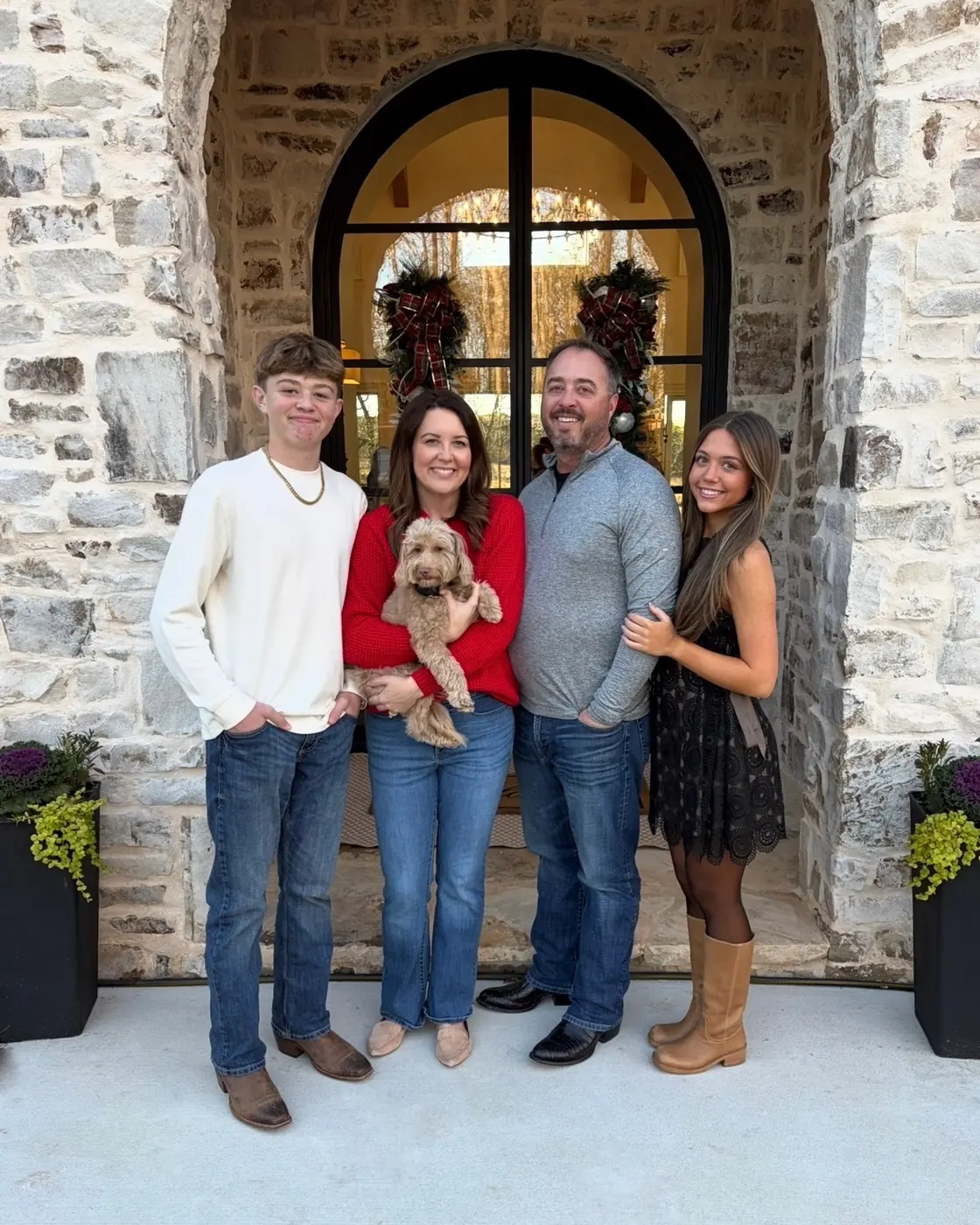 A family of four with their dog, photographed at home.